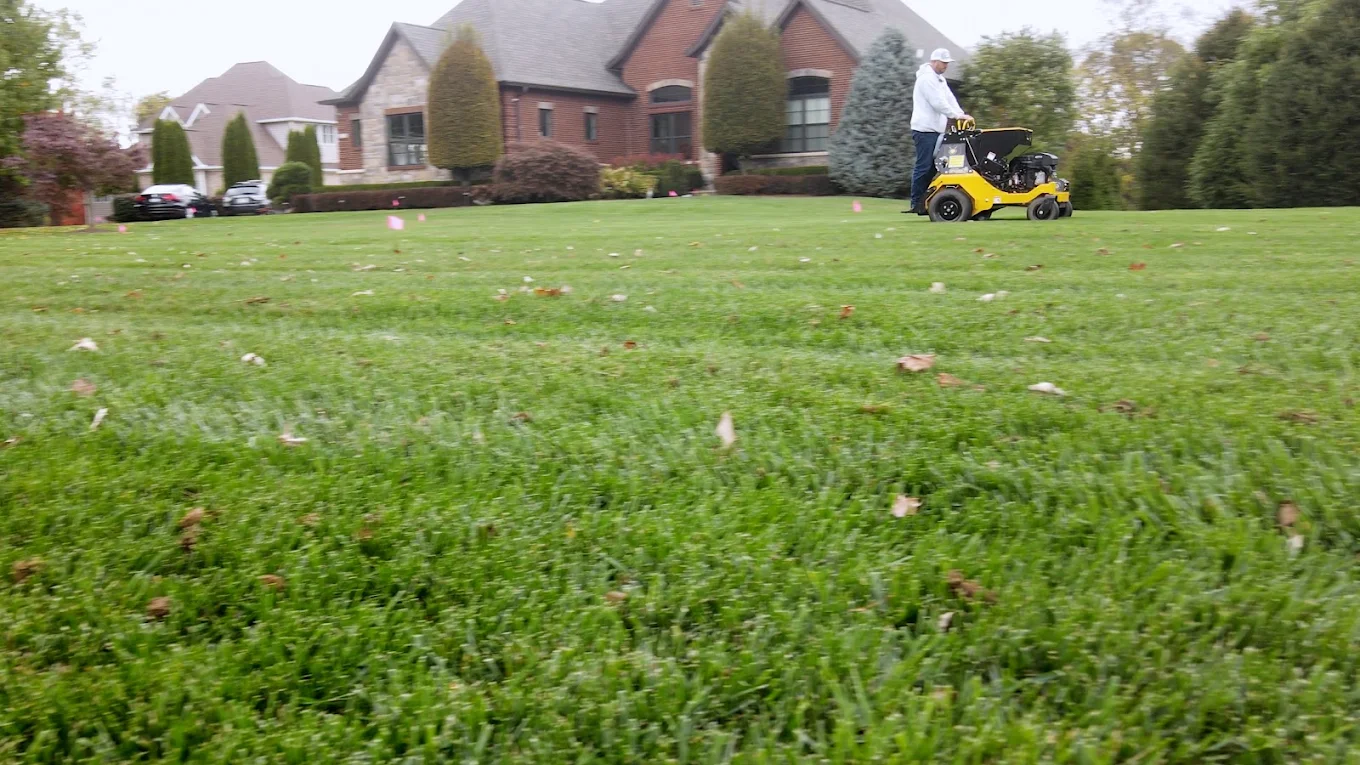 A Lex crew member tending a lawn in front of a Southern Indiana home